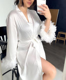 Robe made of satin with feathers on the sleeves